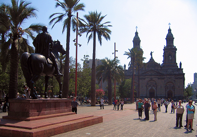 Plaza de Armas in Chile. Frame your shots from the edge of the square instead of the center. Using the palm trees and stone walkways as natural borders keeps the cathedral in focus while capturing the energy of the crowd below.