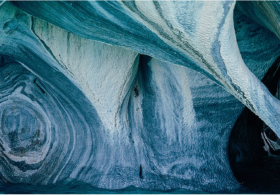 Marble Caves in Chile. Look closely at the streaks of white, gray, and pale blue running through the rock. As waves ripple underneath, the moving light makes the stone walls look completely different from one moment to the next.